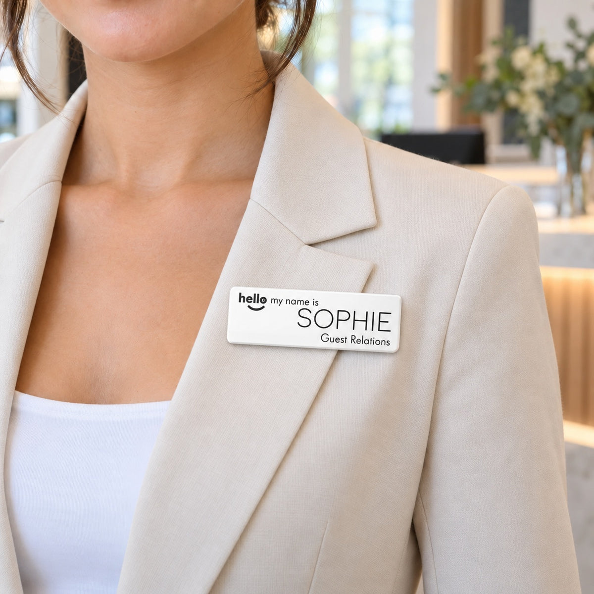 White Hello My Name Is name badge, Option 1, worn on a blazer at a hotel reception