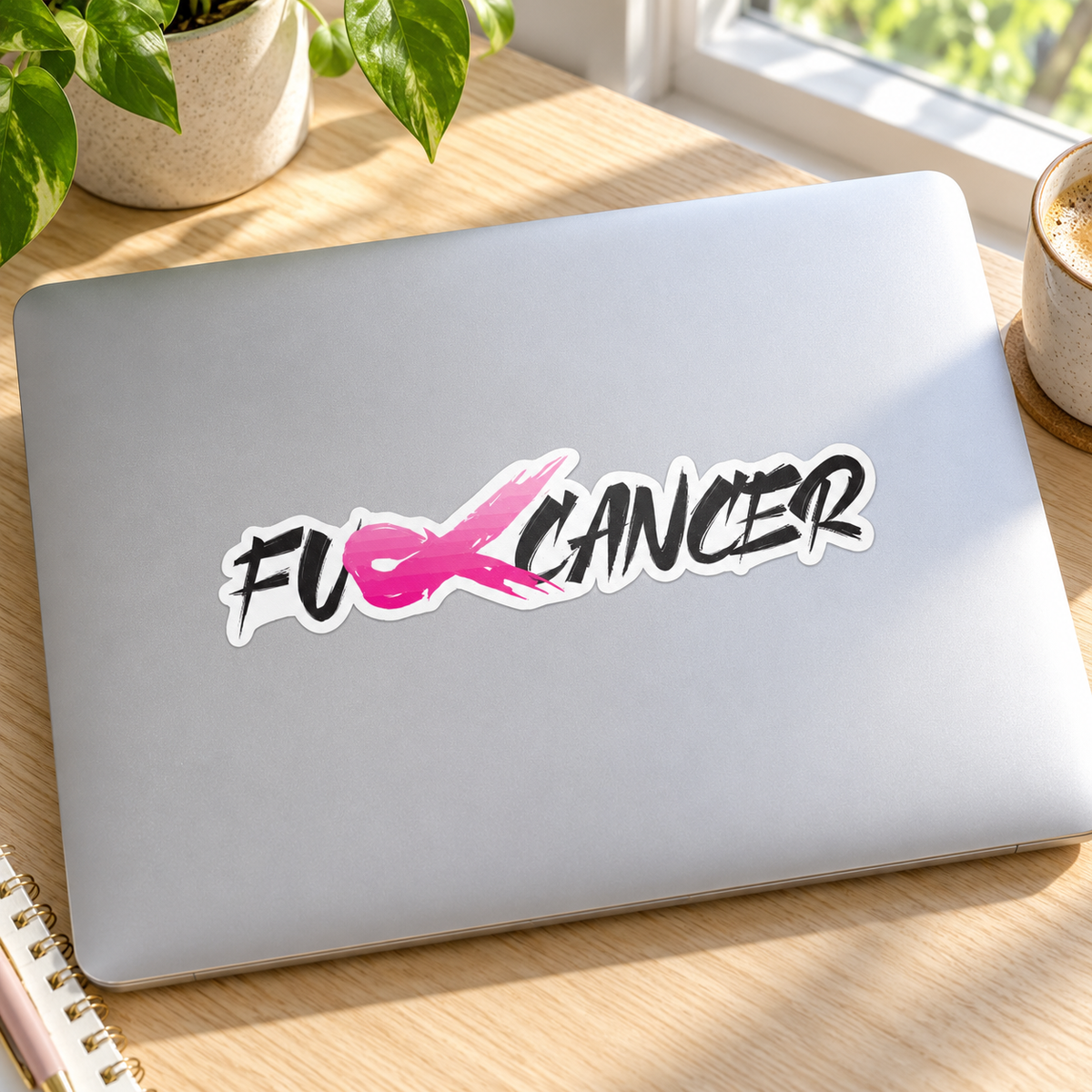 Pink ribbon cancer sticker on a silver laptop lid